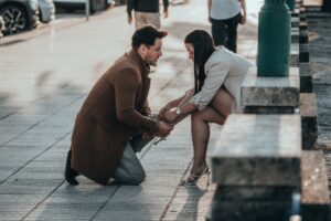 a man helping his girlfriend tying her shoe