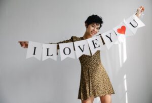 smiling woman standing with inscription on flag garland